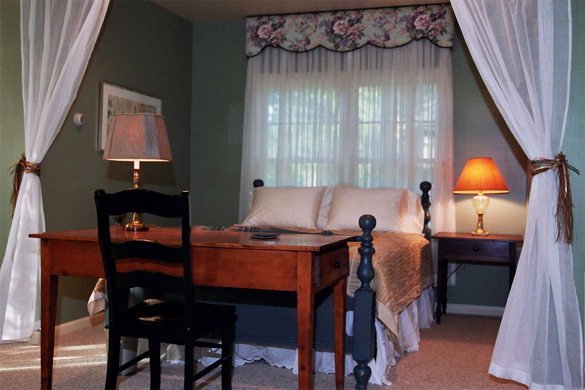 Sleeping area of The Red Cottage with desk